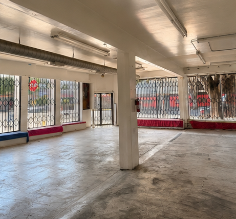 Interior shell — single column, exposed ductwork, two-sided window line.
